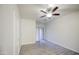 Bright bedroom with wood-look flooring, ceiling fan, and a sliding door to the backyard at 1624 N 77Th Gln, Phoenix, AZ 85035
