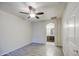 Neutral bedroom featuring wood-look flooring and a ceiling fan; attached bathroom is visible at 1624 N 77Th Gln, Phoenix, AZ 85035