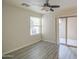 Bright bedroom features wood-look floors, a ceiling fan, and sliding glass door access to a balcony at 1624 N 77Th Gln, Phoenix, AZ 85035