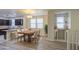 Open-concept dining area with a wooden table, white chairs, and a modern chandelier at 1624 N 77Th Gln, Phoenix, AZ 85035