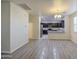 Spacious living room showcasing wood-look floors that lead into the dining and kitchen area at 1624 N 77Th Gln, Phoenix, AZ 85035