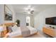 Comfortable main bedroom with a wooden bed frame, a ceiling fan, and an ensuite bathroom at 1624 N 77Th Gln, Phoenix, AZ 85035