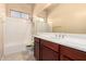 Bathroom featuring tile flooring, a bathtub-shower combo and a wooden vanity with chrome fixtures at 18322 W Sweet Acacia Dr, Goodyear, AZ 85338