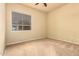 Bedroom with neutral tones, carpeted flooring, a ceiling fan and a window creating a calm retreat at 18322 W Sweet Acacia Dr, Goodyear, AZ 85338
