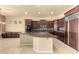 Gourmet kitchen boasts dark wood cabinetry, large island, and stainless steel appliances at 18322 W Sweet Acacia Dr, Goodyear, AZ 85338