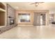 Open-concept living room with tile flooring, ceiling fan and a beautiful stone fireplace at 18322 W Sweet Acacia Dr, Goodyear, AZ 85338