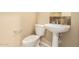 Convenient powder room features a pedestal sink and decorative mirror at 18322 W Sweet Acacia Dr, Goodyear, AZ 85338
