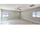 This bedroom features a ceiling fan, tile flooring, and two large windows at 20411 W Mountain Sage W Dr, Buckeye, AZ 85326