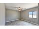 Bright bedroom with tile flooring, ceiling fan, and a view of the outside at 20419 W Mountain Sage Dr, Buckeye, AZ 85326