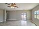 Large living room with tiled floors, fan, and sliding glass door at 20419 W Mountain Sage Dr, Buckeye, AZ 85326