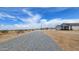 Scenic street view leading to a modern home, showcasing the tranquil neighborhood and clear blue skies at 20419 W Mountain Sage Dr, Buckeye, AZ 85326