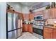 Kitchen with stainless steel refrigerator and oven, brown cabinets, granite countertops and decorative backsplash at 2101 S Meridian Rd # 250, Apache Junction, AZ 85120