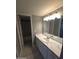 Bathroom with marble countertop vanity, sink, and a large mirror with modern lighting at 2121 W Royal Palm Rd # 1014, Phoenix, AZ 85021