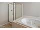 Bright bathroom featuring a combined shower and tub with glass enclosure and a well-maintained white tub at 21675 N 61St Ave, Glendale, AZ 85308