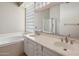 Well-lit bathroom featuring a double sink vanity, a large mirror, and a window providing natural light at 21675 N 61St Ave, Glendale, AZ 85308