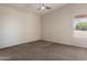 Bright, carpeted bedroom featuring a ceiling fan and a window with blinds for adjustable natural light at 21675 N 61St Ave, Glendale, AZ 85308