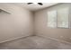 Neutral bedroom with plush carpet, a ceiling fan, and a window allowing ample natural light to enter at 21675 N 61St Ave, Glendale, AZ 85308