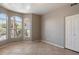Bright bedroom with neutral walls, tiled floor, a closet, and large windows providing natural light and neighborhood views at 21675 N 61St Ave, Glendale, AZ 85308
