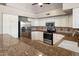 Well-appointed kitchen featuring stainless steel appliances, granite countertops, tile backsplash, and ample cabinet space at 21675 N 61St Ave, Glendale, AZ 85308