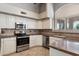 Well-appointed kitchen featuring stainless steel appliances, granite countertops, tile backsplash, and ample cabinet space at 21675 N 61St Ave, Glendale, AZ 85308