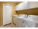 Efficient laundry room equipped with a washer, dryer, sink, and cabinetry for organized storage solutions at 21675 N 61St Ave, Glendale, AZ 85308
