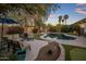 Serene backyard featuring a custom pool, lush landscaping, and comfortable seating areas at 24121 N 24Th Pl, Phoenix, AZ 85024