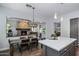 Open concept kitchen with island, pendant lighting, stone fireplace, and an open dining space, ideal for entertaining at 24121 N 24Th Pl, Phoenix, AZ 85024