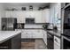 Bright kitchen with white cabinets, black countertops, stainless steel appliances, and modern backsplash for a sleek design at 24121 N 24Th Pl, Phoenix, AZ 85024