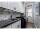 Well-equipped laundry room with ample storage, stylish backsplash, and modern appliances at 24121 N 24Th Pl, Phoenix, AZ 85024