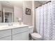 Well-lit bathroom with a white vanity, framed mirror, and stylish shower curtain at 2543 N 73Rd Dr, Phoenix, AZ 85035