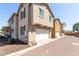 Exterior view of townhome featuring a garage, neutral siding, and manicured landscaping at 2543 N 73Rd Dr, Phoenix, AZ 85035