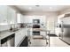Modern kitchen featuring white cabinets, stainless steel appliances, and a movable island at 2543 N 73Rd Dr, Phoenix, AZ 85035