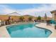 Lush backyard pool area with privacy walls, patio seating and barbeque at 25955 W Deer Valley Rd, Buckeye, AZ 85396