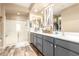 Spacious bathroom with a double vanity, walk-in shower, and neutral decor with wood-look tile flooring at 25955 W Deer Valley Rd, Buckeye, AZ 85396