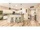 Modern kitchen with white cabinets, stainless appliances, breakfast bar with seating, and wood-look tile flooring at 25955 W Deer Valley Rd, Buckeye, AZ 85396