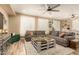 Spacious living room with hardwood floors, a large sectional couch, and a modern coffee table at 25955 W Deer Valley Rd, Buckeye, AZ 85396