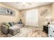 Comfortable living room featuring a stylish gray sectional couch and wood-look floors at 25955 W Deer Valley Rd, Buckeye, AZ 85396