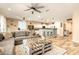 Open-concept living room featuring hardwood floors, a large sectional couch, and a modern kitchen at 25955 W Deer Valley Rd, Buckeye, AZ 85396