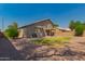 Low-maintenance backyard with gravel and grass, featuring an exterior elevation and covered patio at 321 W Betsy Ln, Gilbert, AZ 85233