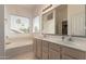 Bathroom with double sinks, a soaking tub, and a large window at 321 W Betsy Ln, Gilbert, AZ 85233
