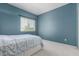 Comfortable bedroom featuring blue walls, soft carpet, and a large window with bright light at 321 W Betsy Ln, Gilbert, AZ 85233