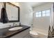 Bright white bathroom with a black vanity, subway tile and combination shower at 3308 N 51St St, Phoenix, AZ 85018