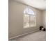 Bedroom featuring a large arched window, neutral carpeting, and ample natural light at 3631 E Long Lake Rd, Phoenix, AZ 85048
