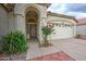 Inviting front entry with security door, desert landscaping, and flowering shrub; the front door has an arched entryway at 3631 E Long Lake Rd, Phoenix, AZ 85048
