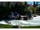 A charming water feature with a small waterfall and a statue, surrounded by lush greenery and palm trees at 3631 E Long Lake Rd, Phoenix, AZ 85048