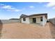 A backyard with a covered patio awaits landscaping and personalization under a partly cloudy sky at 37549 W San Clemente St, Maricopa, AZ 85138
