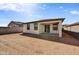 Unlandscaped backyard with a covered patio, block fence, and sliding glass door entry at 37549 W San Clemente St, Maricopa, AZ 85138