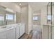 Bright bathroom with double sink vanity, framed mirror and glass shower enclosure at 37549 W San Clemente St, Maricopa, AZ 85138