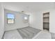 A bedroom featuring neutral carpet, two windows, and a closet with shelving at 37549 W San Clemente St, Maricopa, AZ 85138