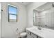 Bright bathroom featuring a white vanity, framed mirror and shower with a window providing natural light at 37551 W Patterson St, Maricopa, AZ 85138